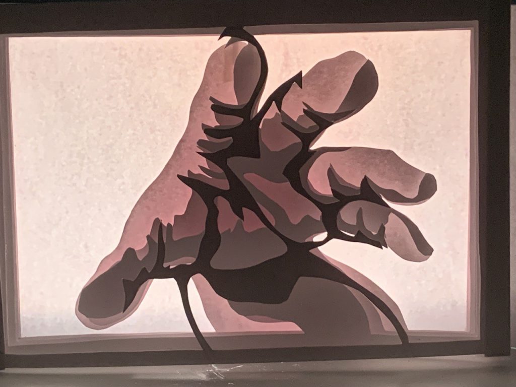 Layered paper sculpture of hand reaching out